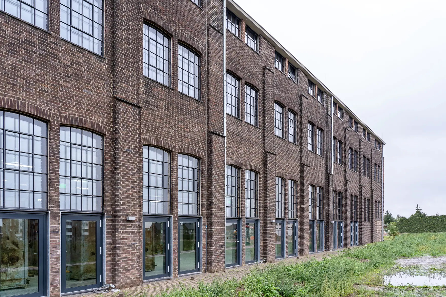 A brick warehouse elevation with steel-framed windows in the Oldgate streets