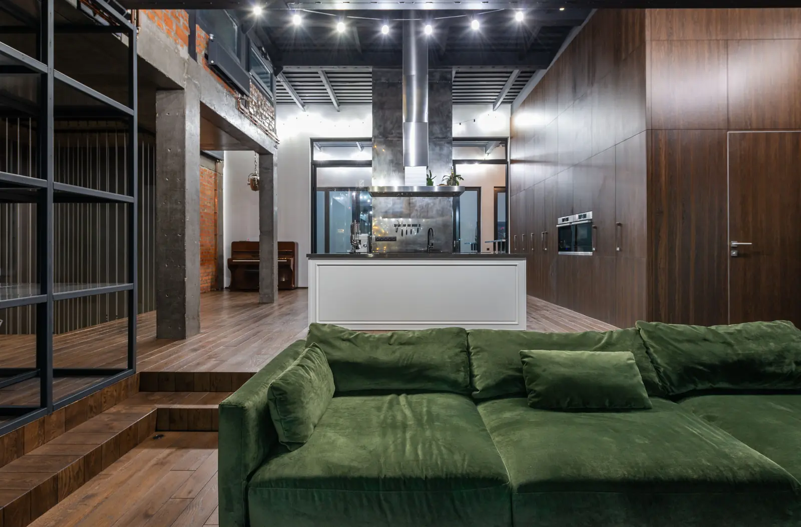 The olive sofa in the living level at Rivergate, the kitchen behind
