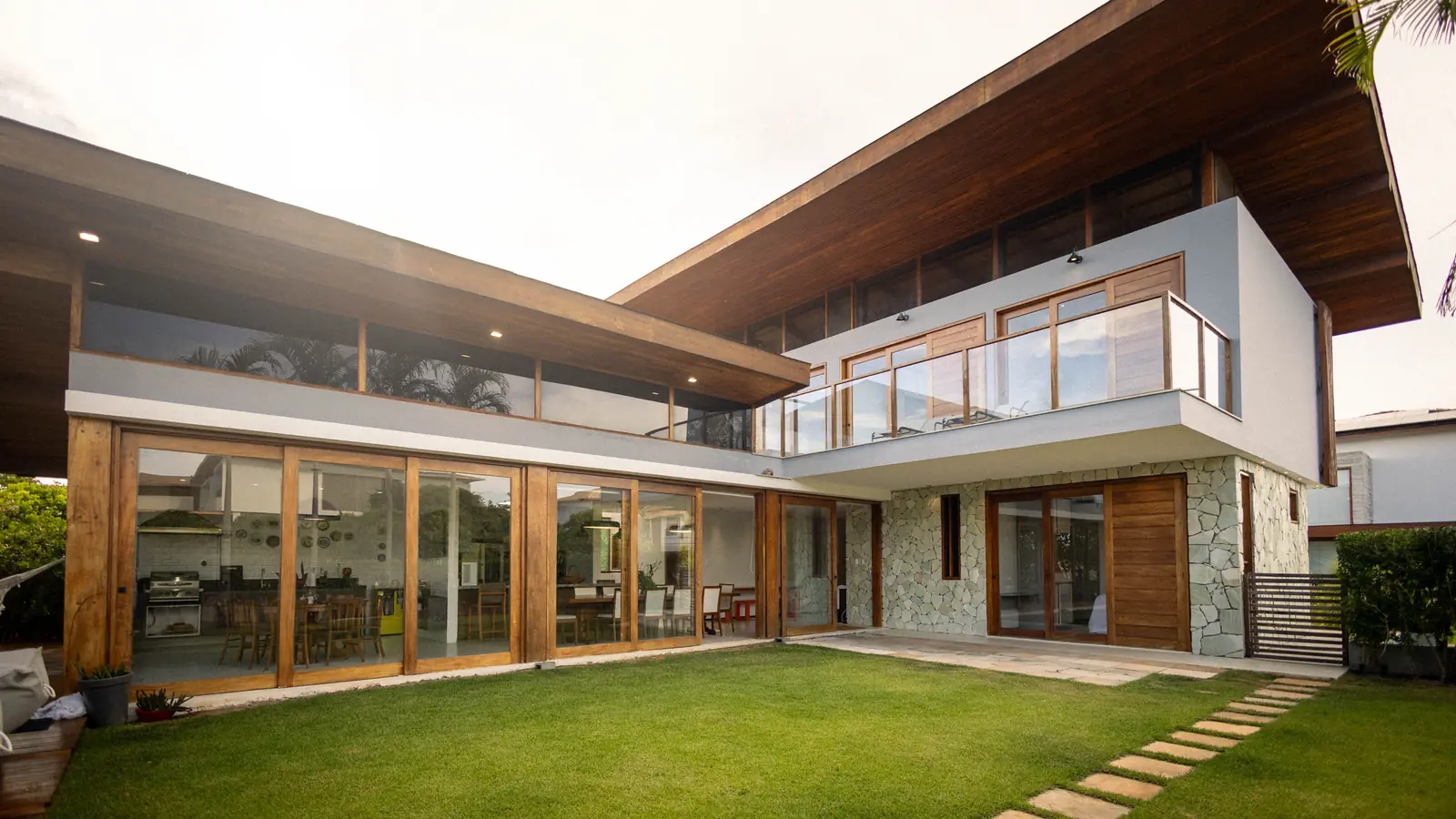 Thornhollow House from the lawn, its timber eaves carried across the glazing