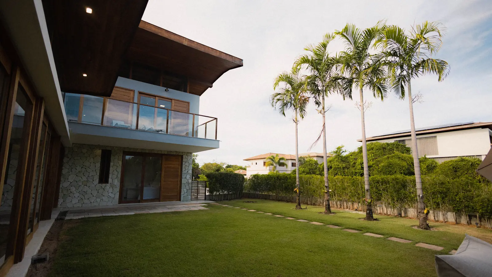 Thornhollow Valley: a house set back across its lawn at the edge of the woodland