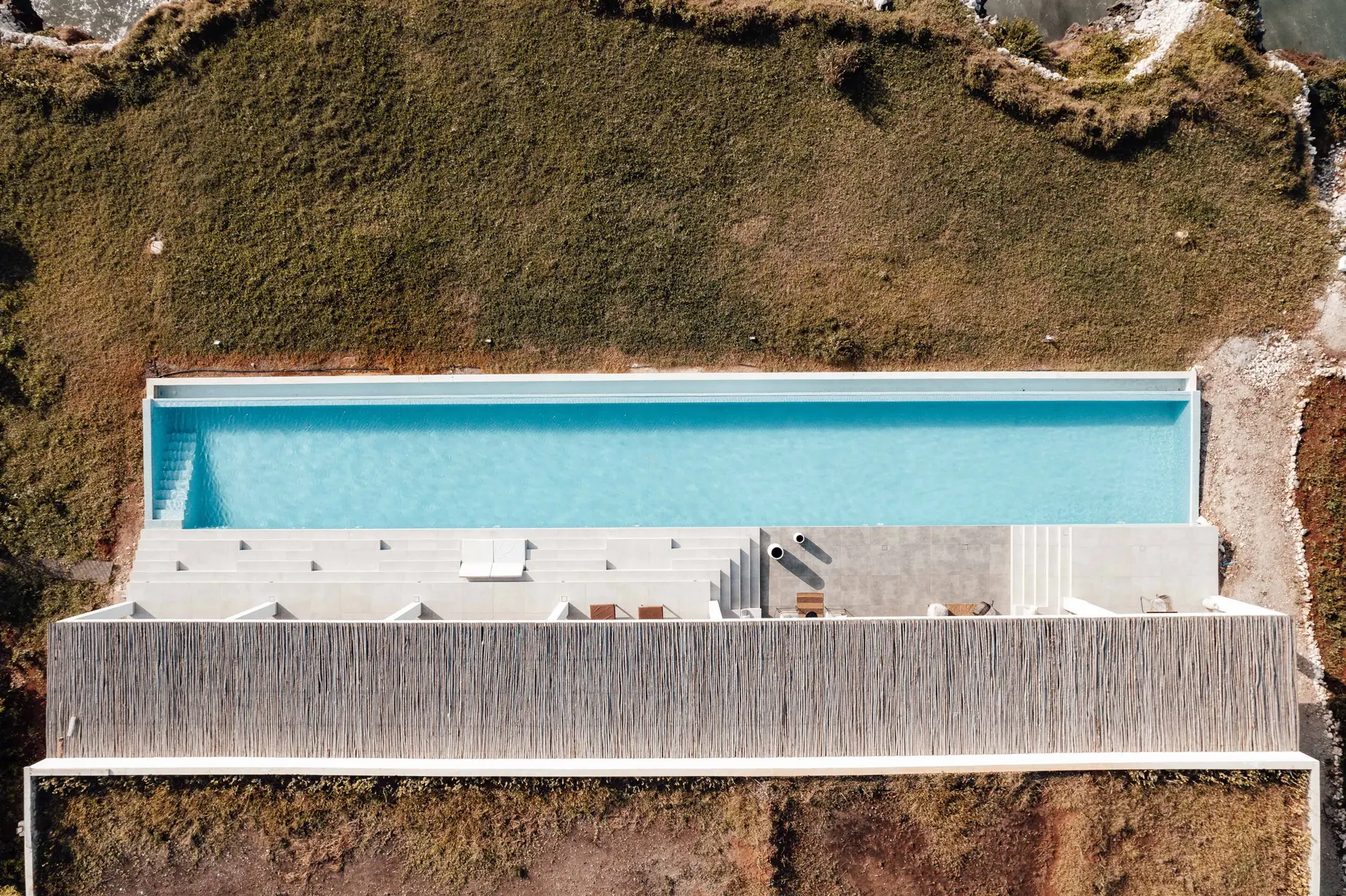 The Cala Verdana headland from the air, a house and its terrace above open water